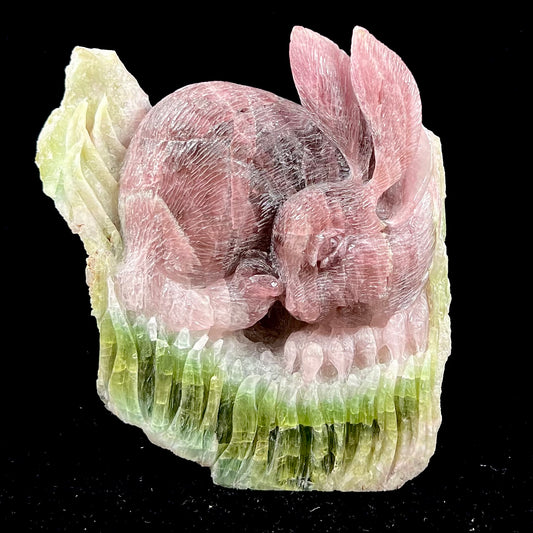 A stone rabbit carved from a conglomeration of watermelon tourmaline crystals by artist, Ronald Stevens.