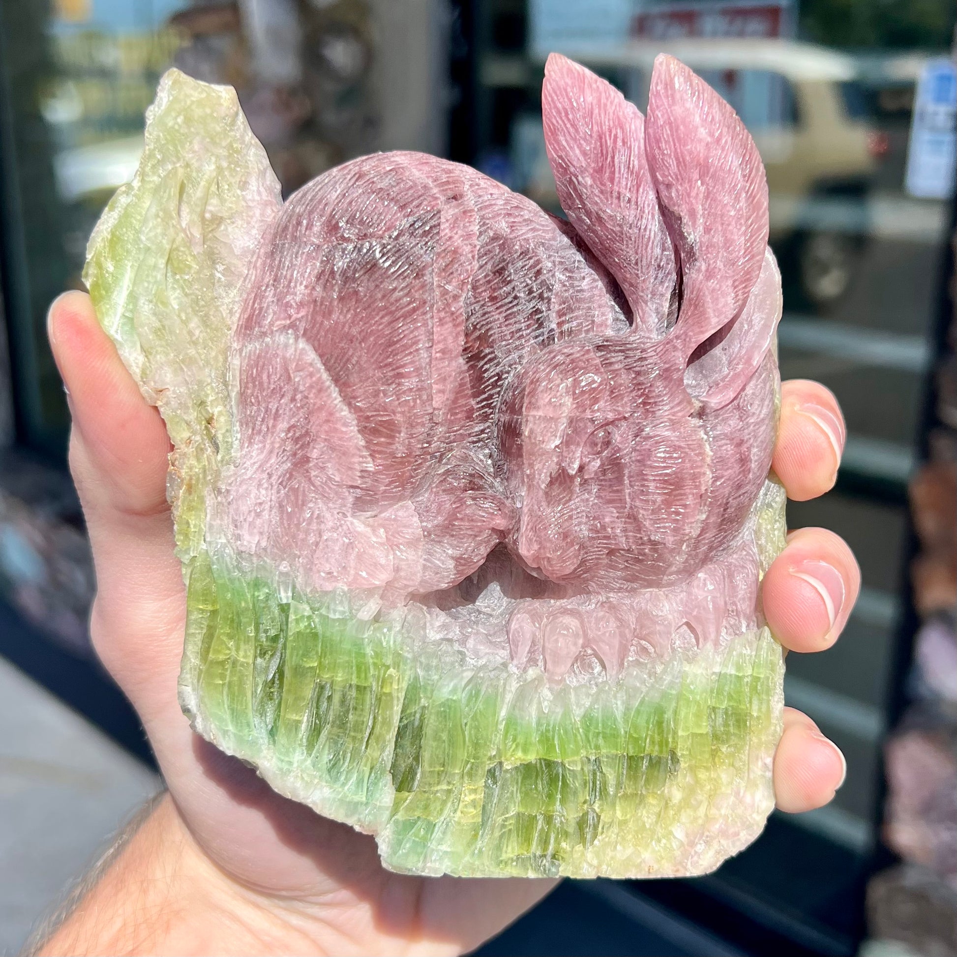 A stone rabbit carved from a conglomeration of watermelon tourmaline crystals by artist, Ronald Stevens.