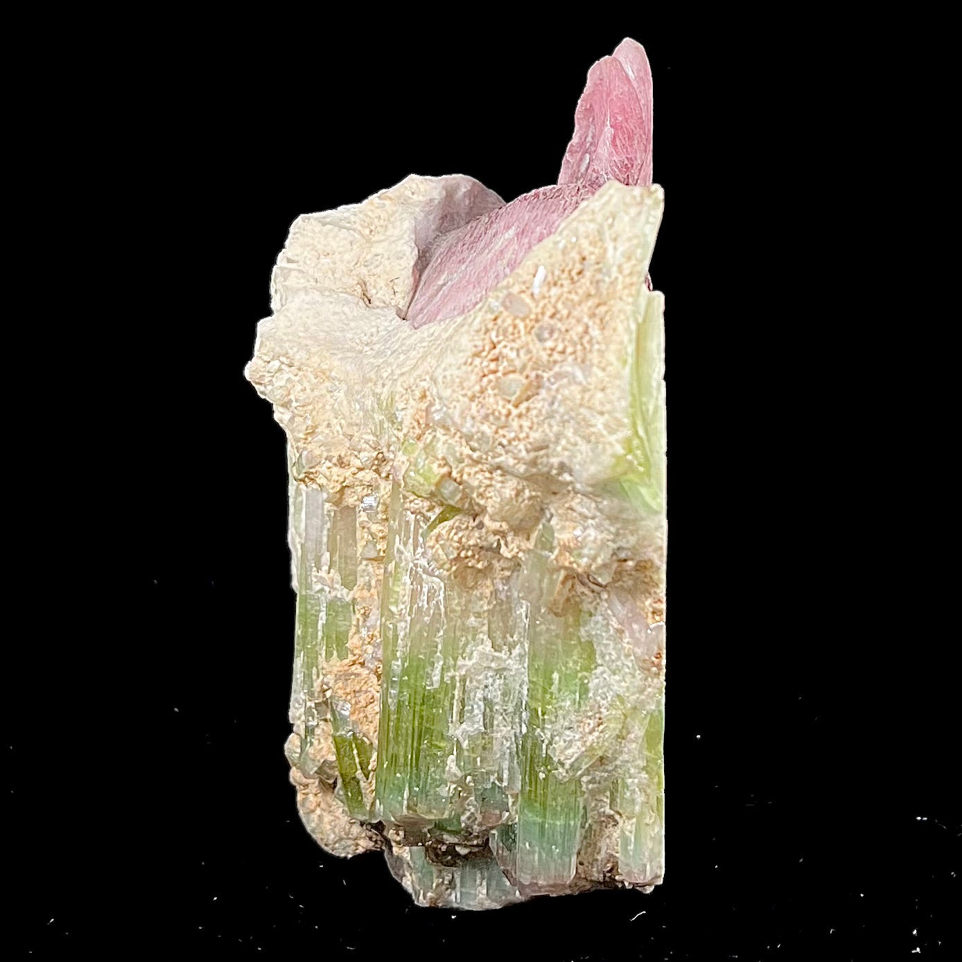 A stone rabbit carved from a conglomeration of watermelon tourmaline crystals by artist, Ronald Stevens.