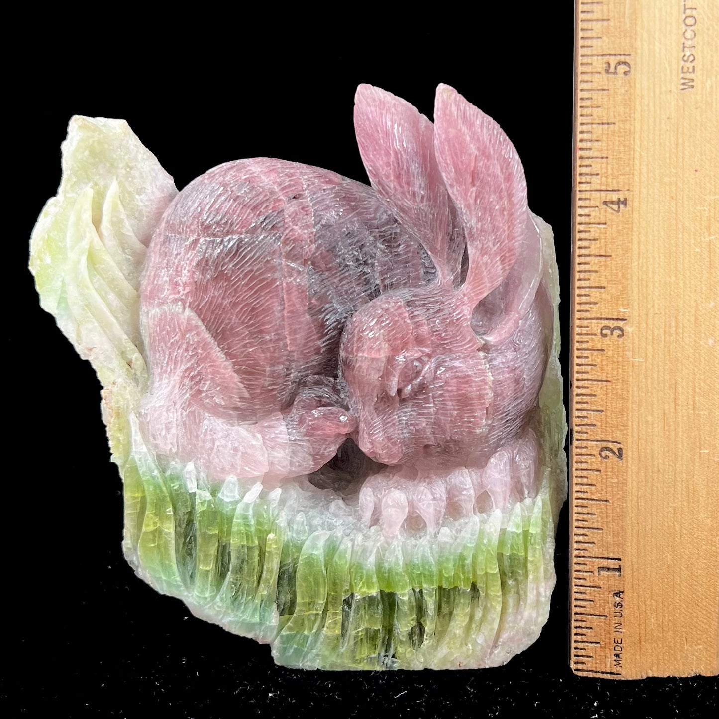 A stone rabbit carved from a conglomeration of watermelon tourmaline crystals by artist, Ronald Stevens.