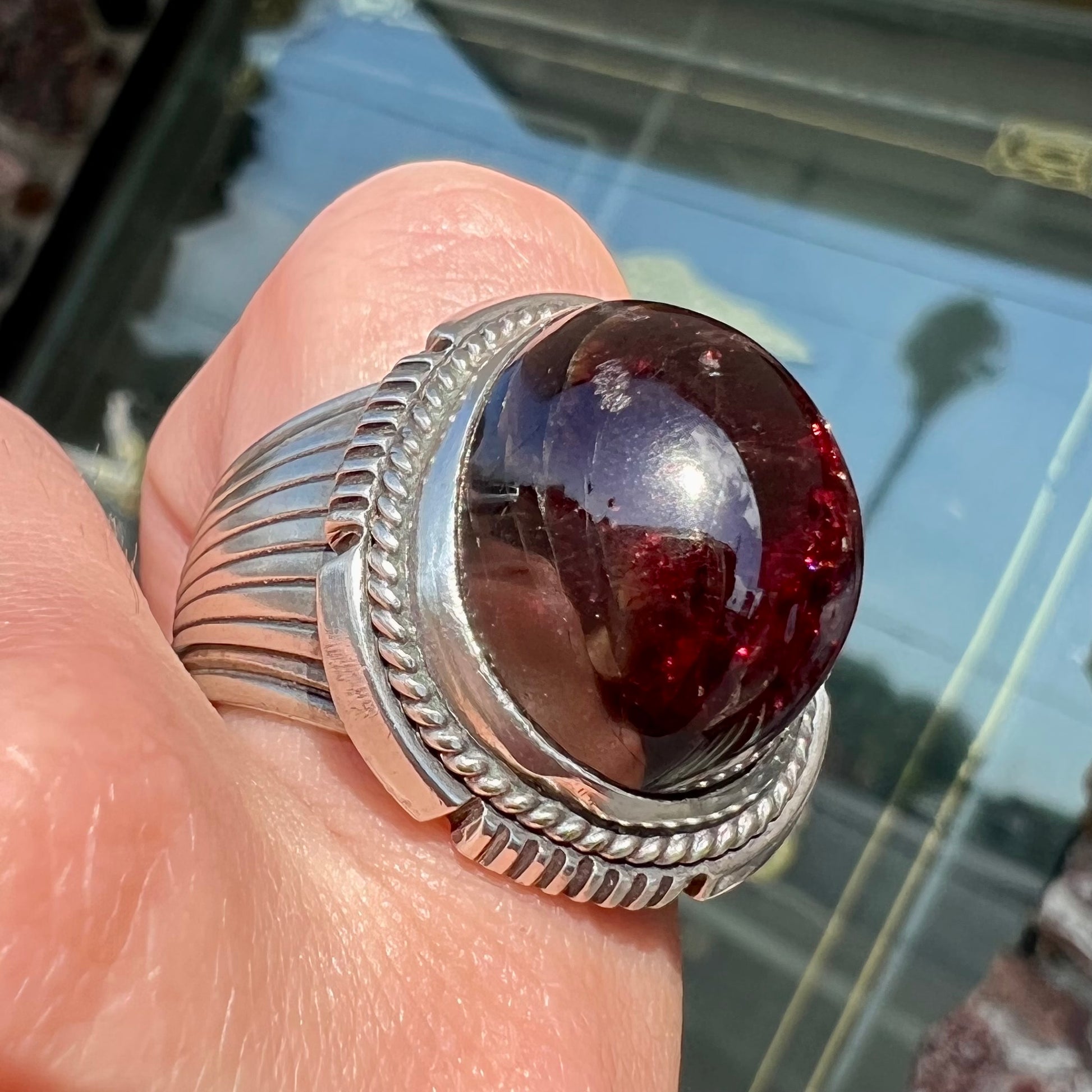 A men's sterling silver garnet ring handmade by Navajo artist Will Denetdale.