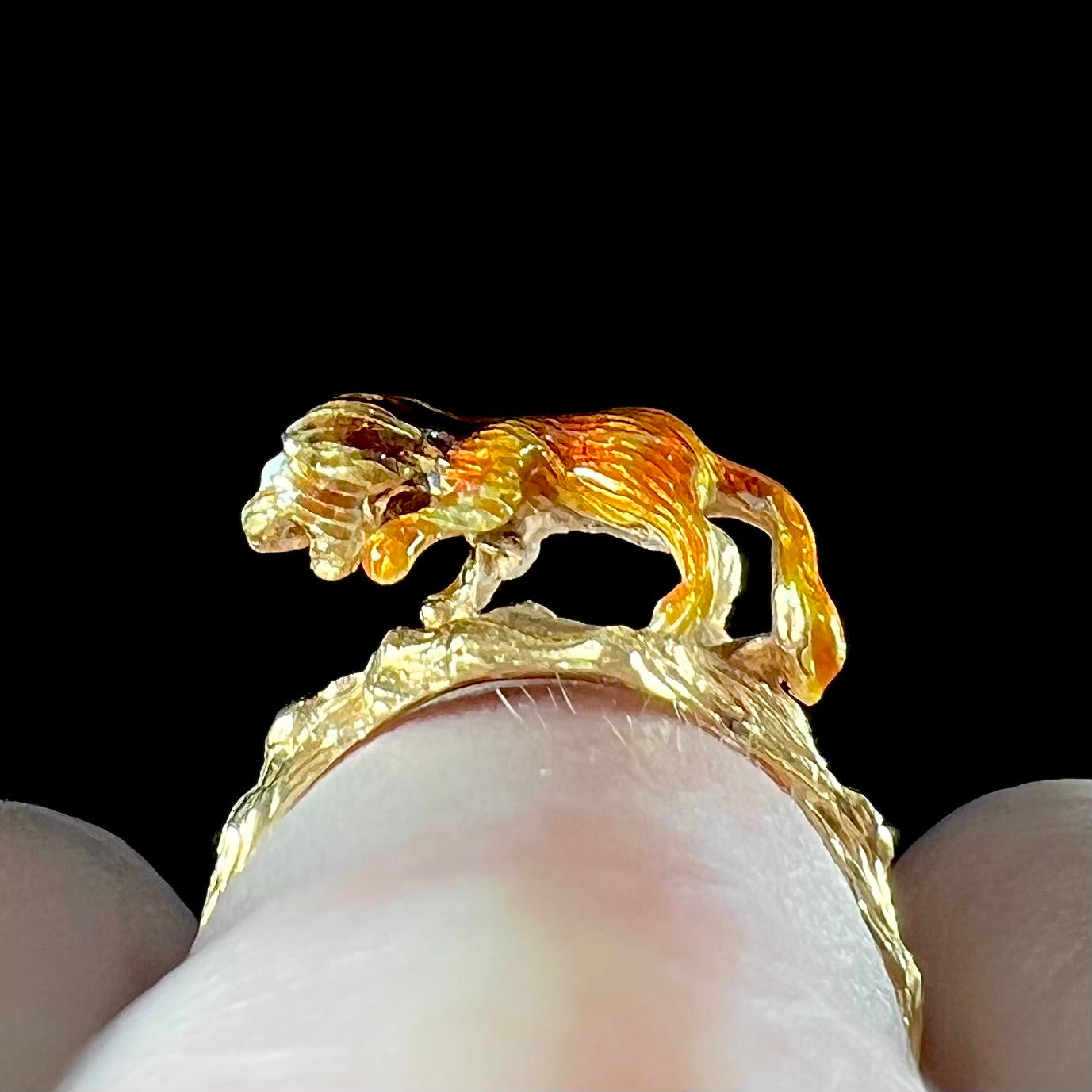 An estate 18kt yellow gold ring featuring a 3D enameled lion walking on a tree branch.