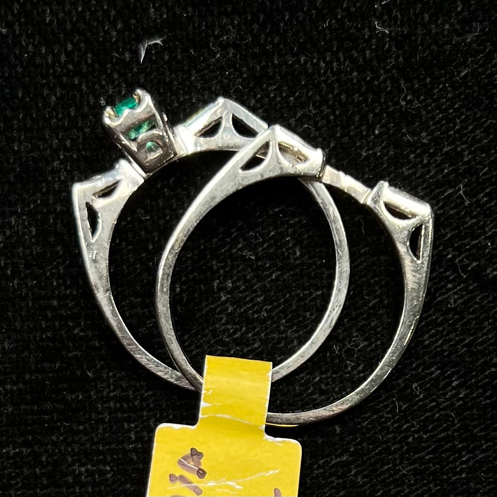 A white gold emerald and baguette cut diamond engagement and wedding set.
