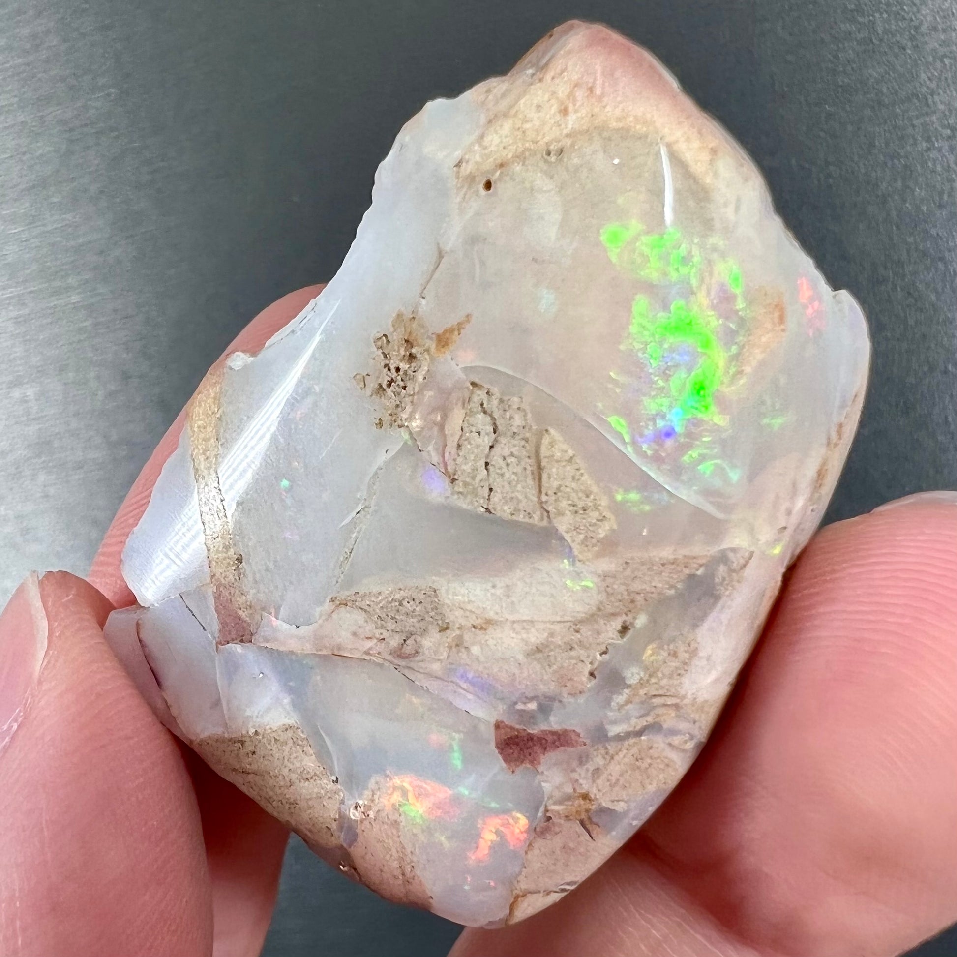 A loose, polished White Cliffs opal specimen.