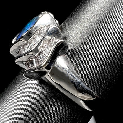 A white gold ring set with a Lightning Ridge natural black opal and baguette cut diamonds.