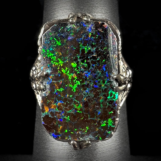 A vintage, white gold filigree unisex ring set with a natural black Koroit boulder opal.