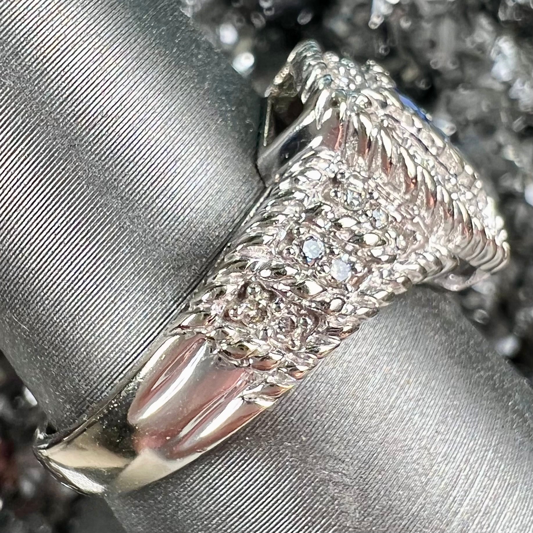 A white gold trillion cut tanzanite ring set with a diamond halo and diamond accents.