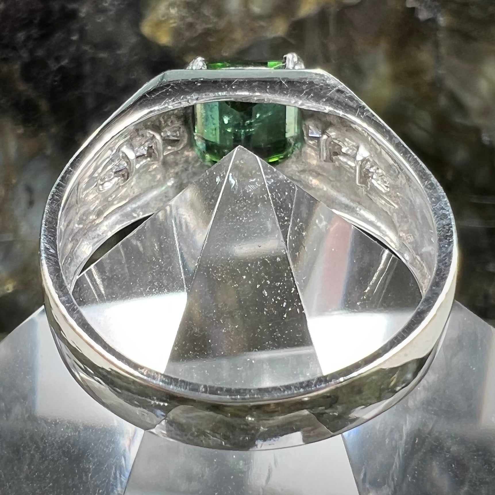 An 18k white gold green tourmaline and diamond men's ring.  The stones are princess cut.
