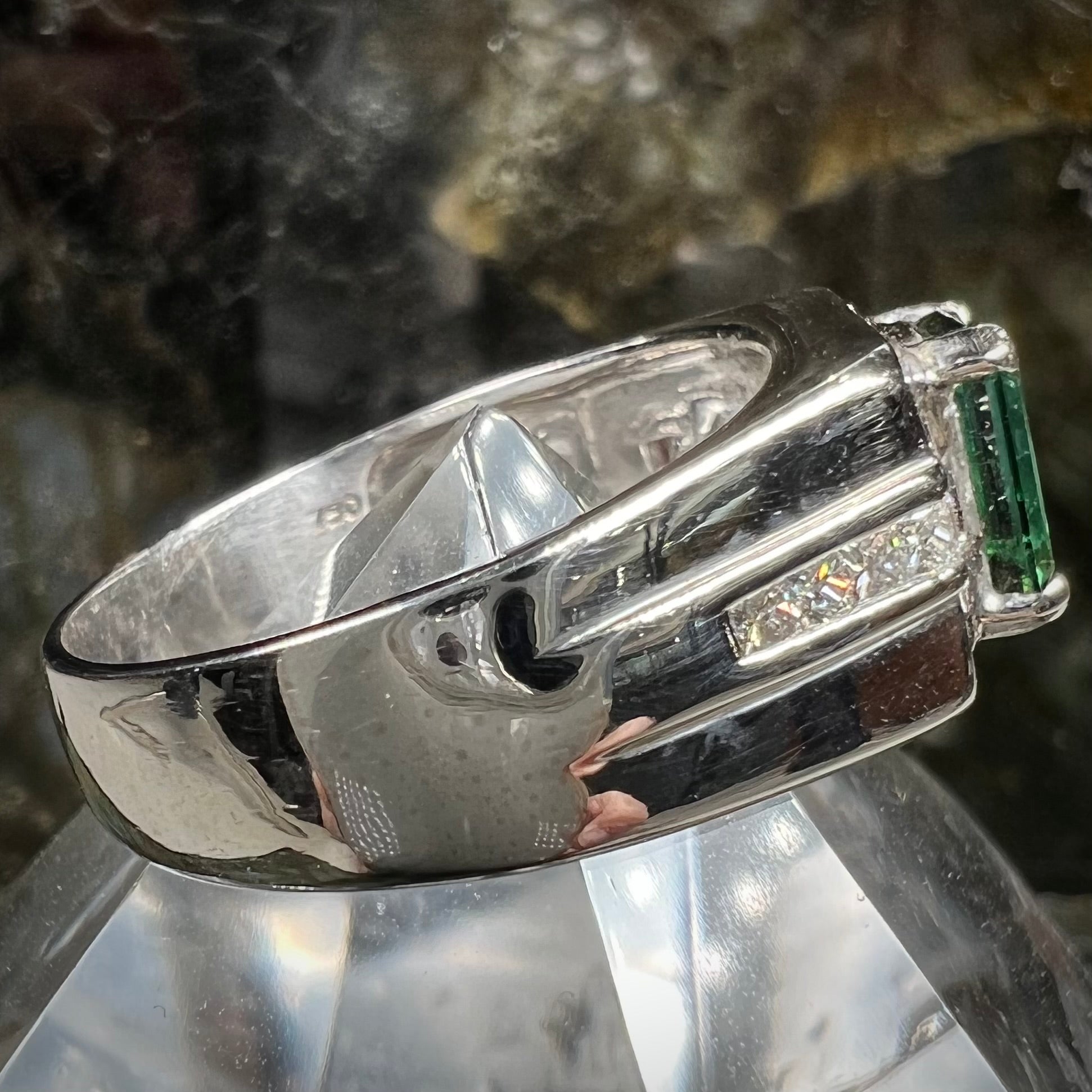 An 18k white gold green tourmaline and diamond men's ring.  The stones are princess cut.