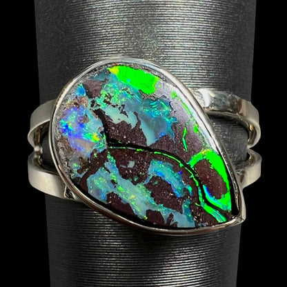 A split shank white gold boulder opal solitaire ring.  The stone has a natural hematite seam that runs through it.