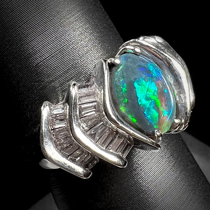 A white gold ring set with a Lightning Ridge natural black opal and baguette cut diamonds.