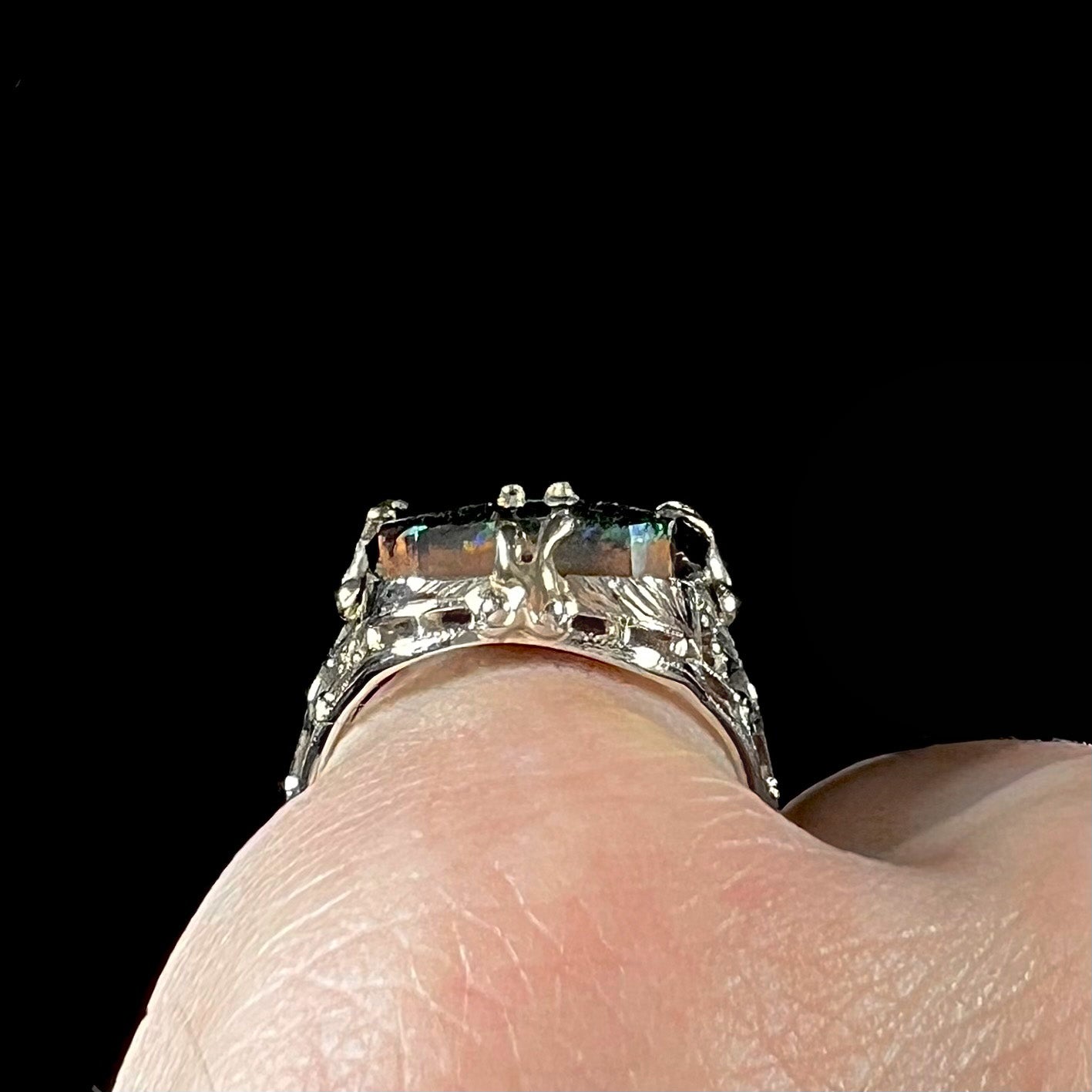 A vintage, white gold filigree unisex ring set with a natural black Koroit boulder opal.