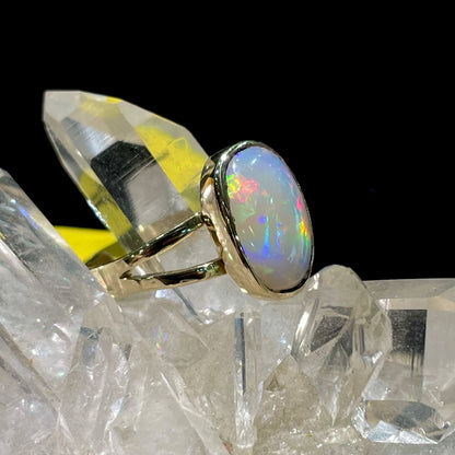 A handmade split shank white opal solitaire ring in yellow gold.