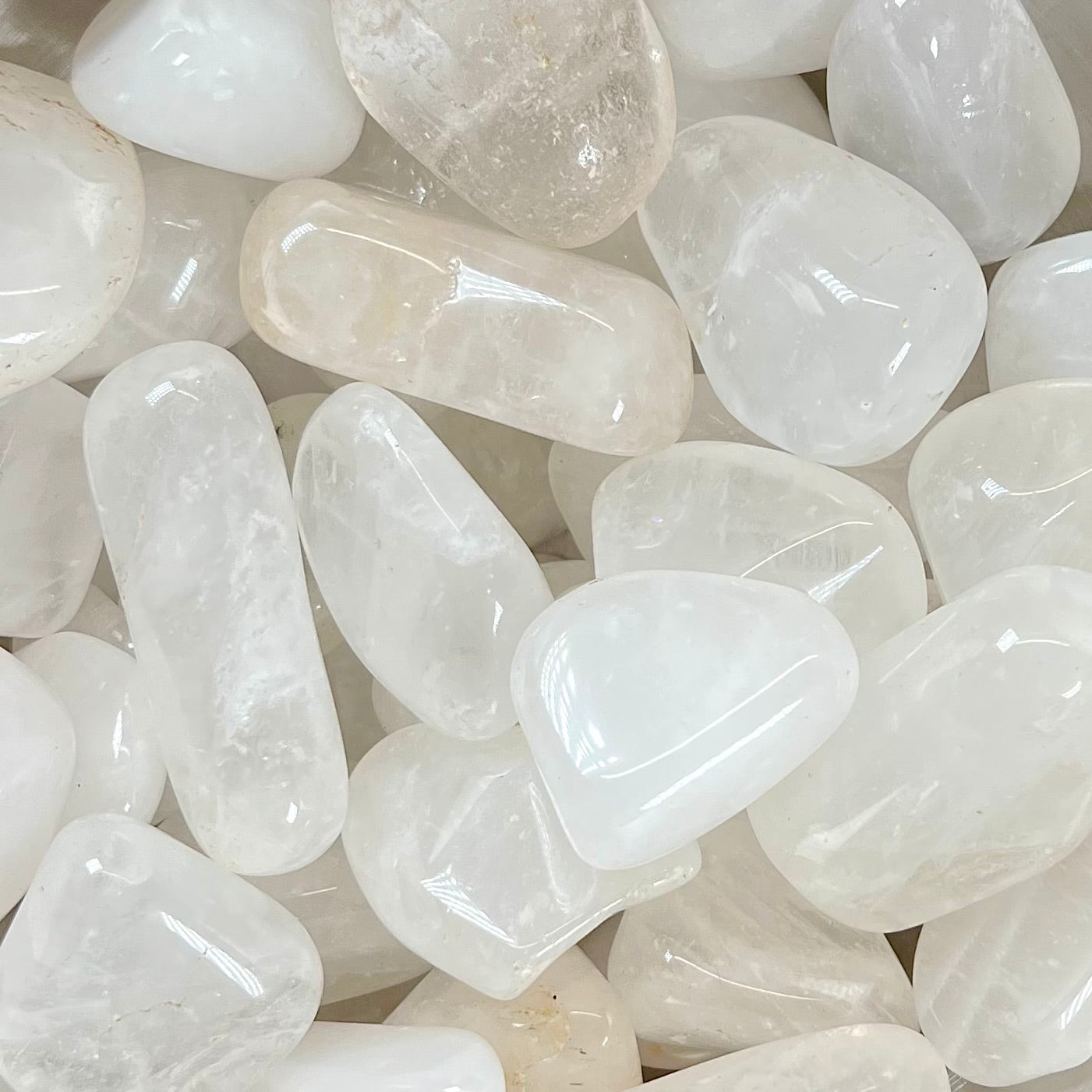 Palm sized tumbled white quartz stones.