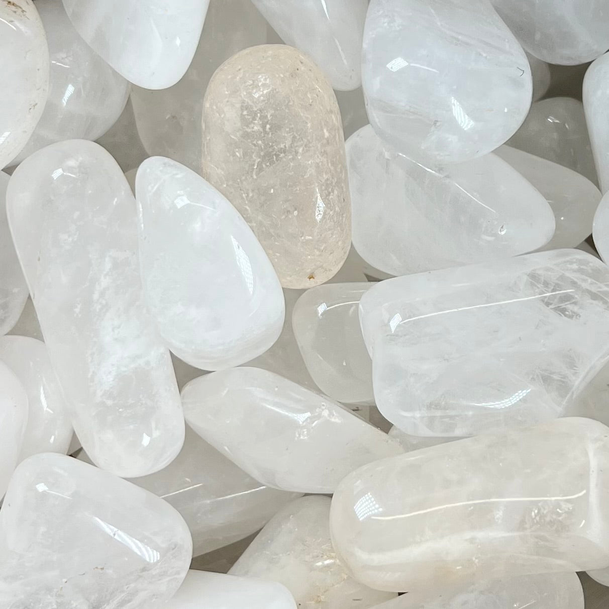 Palm sized tumbled white quartz stones.