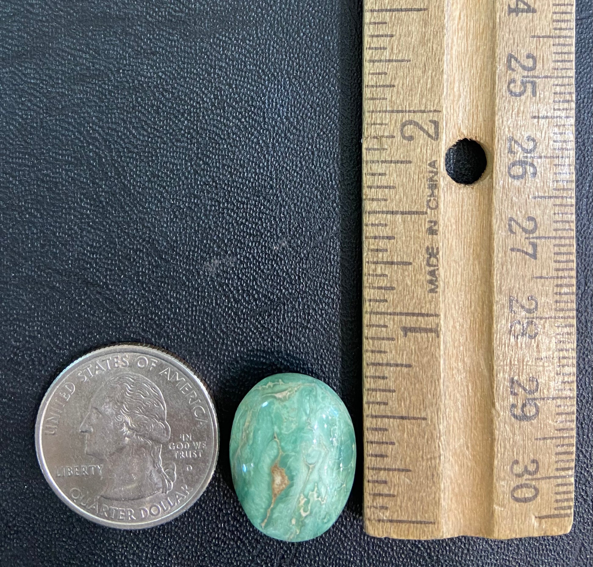 A loose, green oval cabochon cut turquoise stone from the Royston Mining District in Nevada.  Green color marbles around a light brown eye.