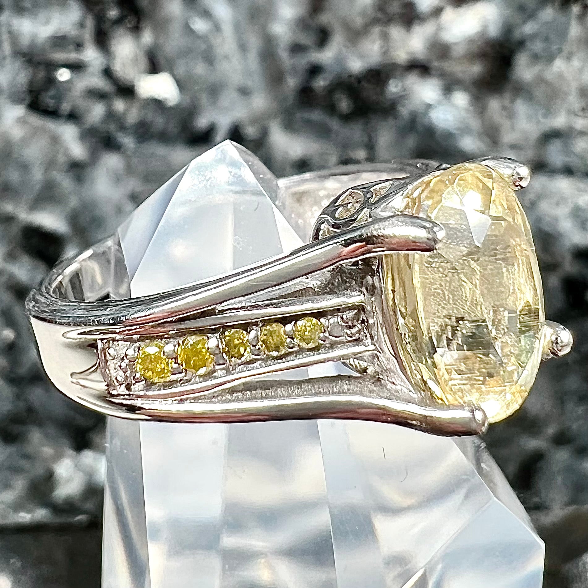 A sterling silver oval cut citrine ring set with canary yellow diamond accents.