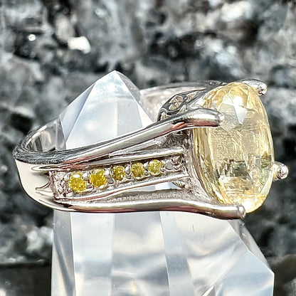A sterling silver oval cut citrine ring set with canary yellow diamond accents.