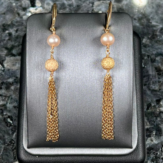 A pair of yellow gold and pink pearl dangle earrings.