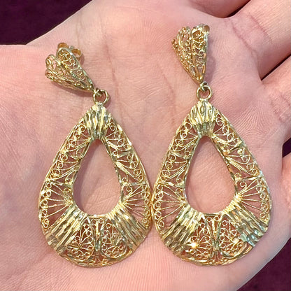 A pair of 14kt yellow gold filigree dangle earrings.  The earrings have a pear shape open design.