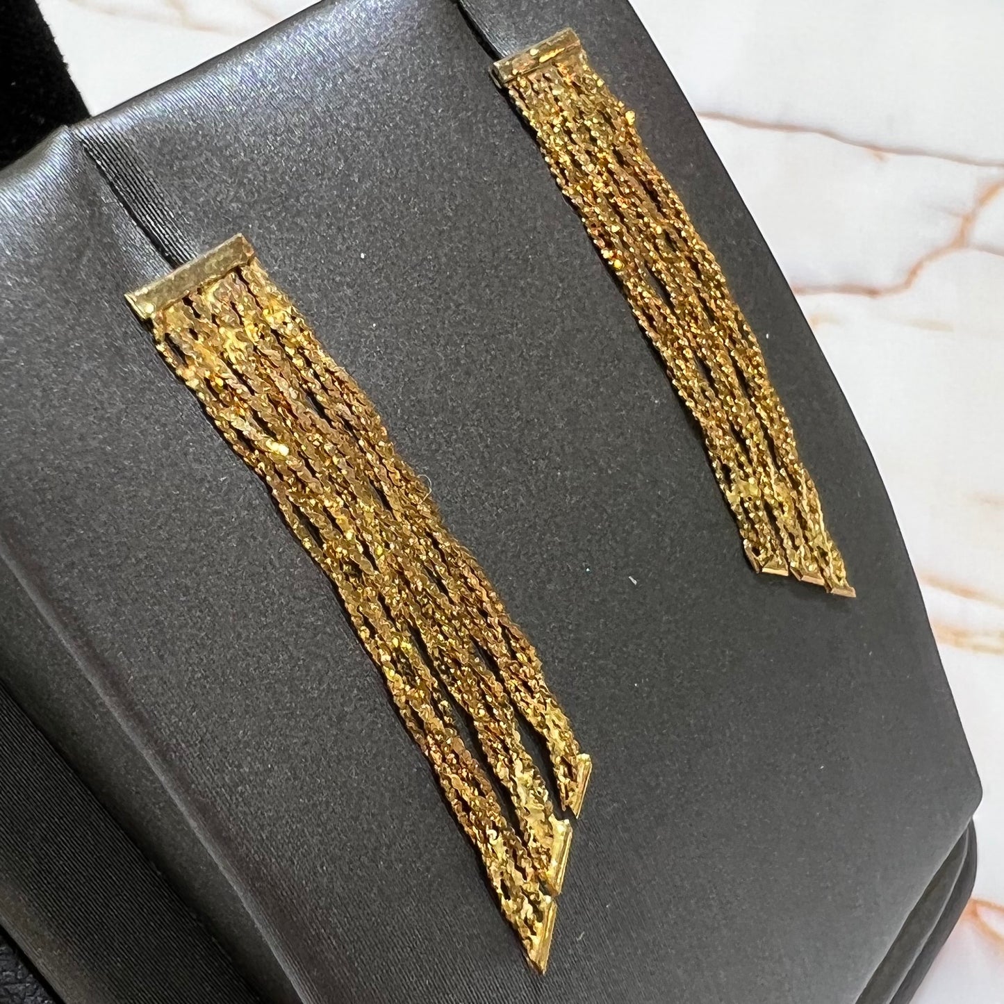 A pair of yellow gold waterfall dangle earrings.