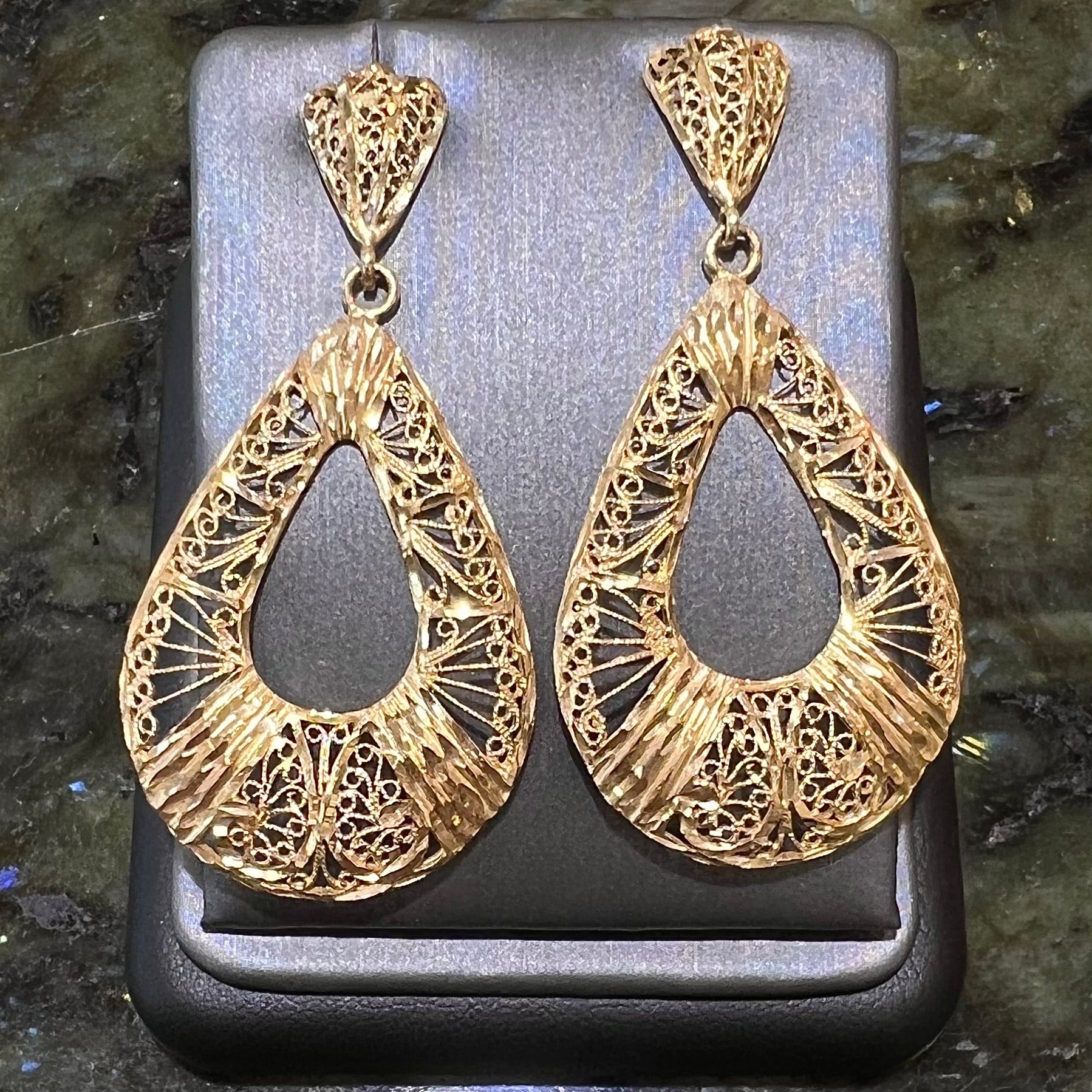 A pair of 14kt yellow gold filigree dangle earrings.  The earrings have a pear shape open design.
