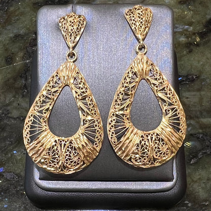 A pair of 14kt yellow gold filigree dangle earrings.  The earrings have a pear shape open design.