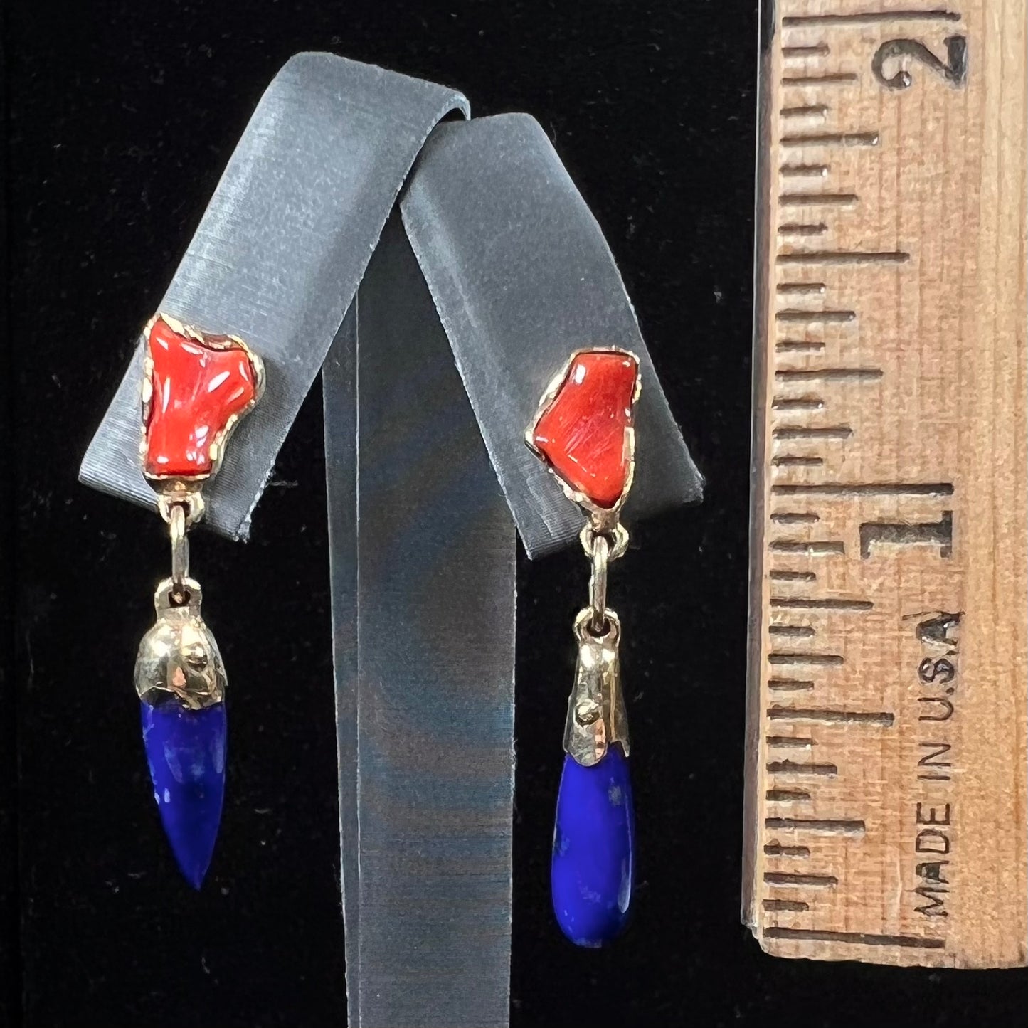 A pair of Navajo-handmade yellow gold dangle earrings set with lapis lazuli and polished coral branches.