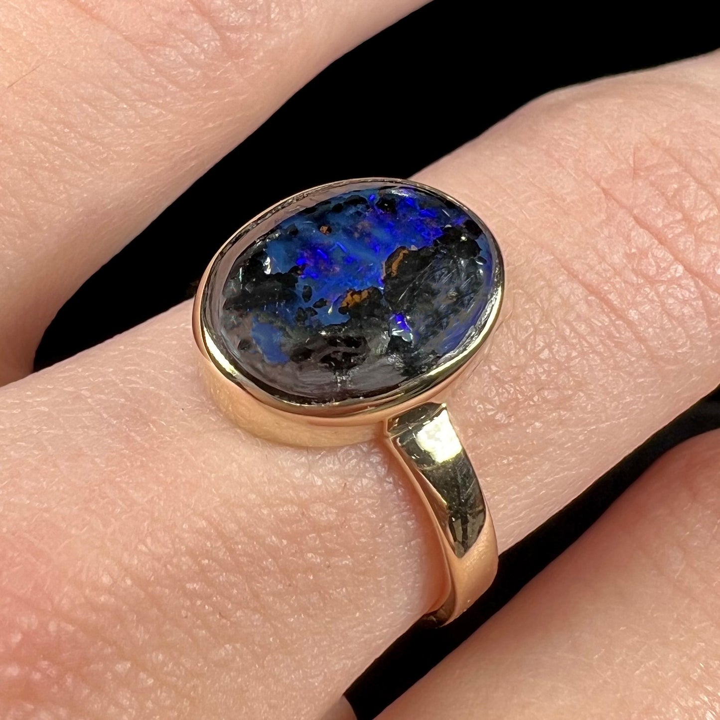 A handmade ladies' yellow gold boulder opal ring.  The opal is a natural purple Yowah nut boulder opal.