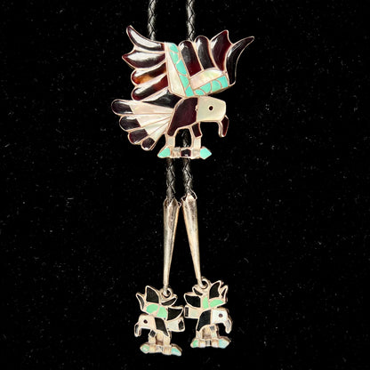 A sterling silver Zuni Indian-made bolo tie featuring the motif of three flying eagles inlaid with natural stones.