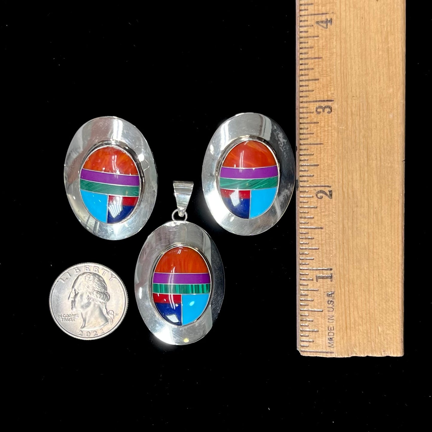 A Zuni-style pendant and earring set inlaid with spiny oyster, sugilite, malachite, turquoise, coral, and lapis lazuli stones.