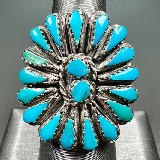 A handmade, sterling silver Zuni Indian ring petit point set with turquoise stones.  The ring has a split shank.