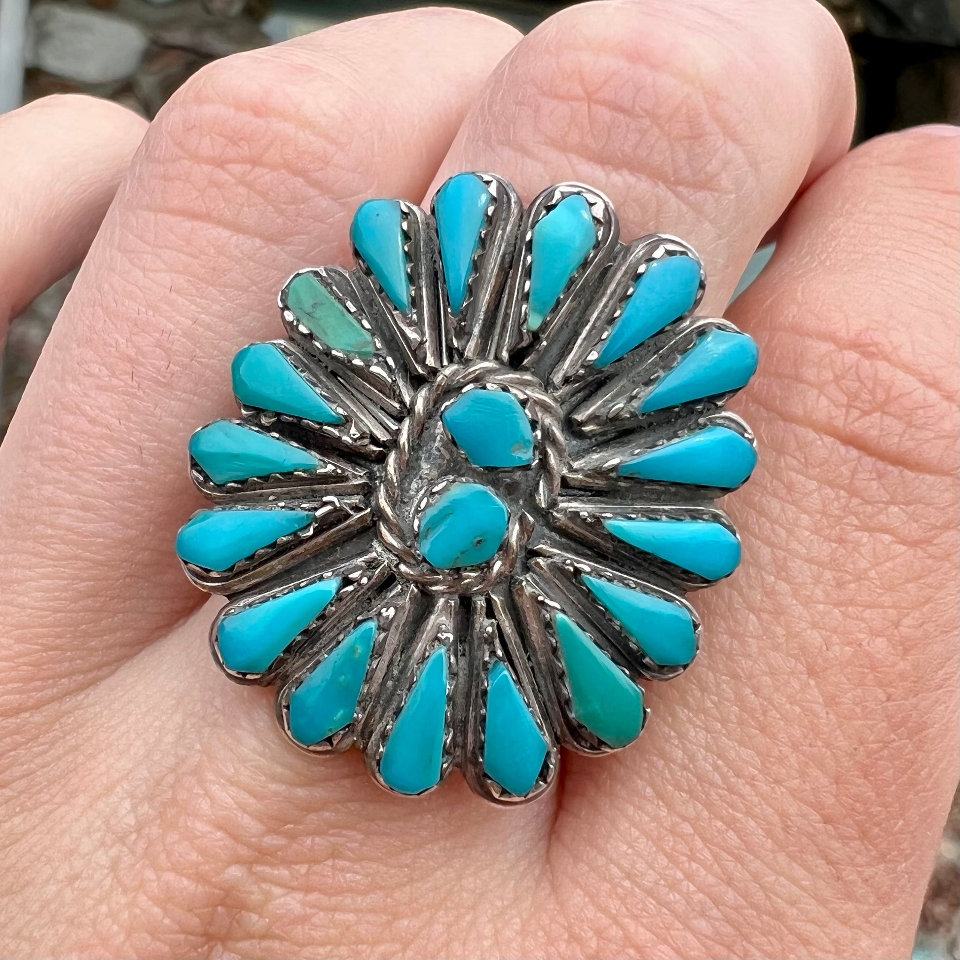 A handmade, sterling silver Zuni Indian ring petit point set with turquoise stones.  The ring has a split shank.