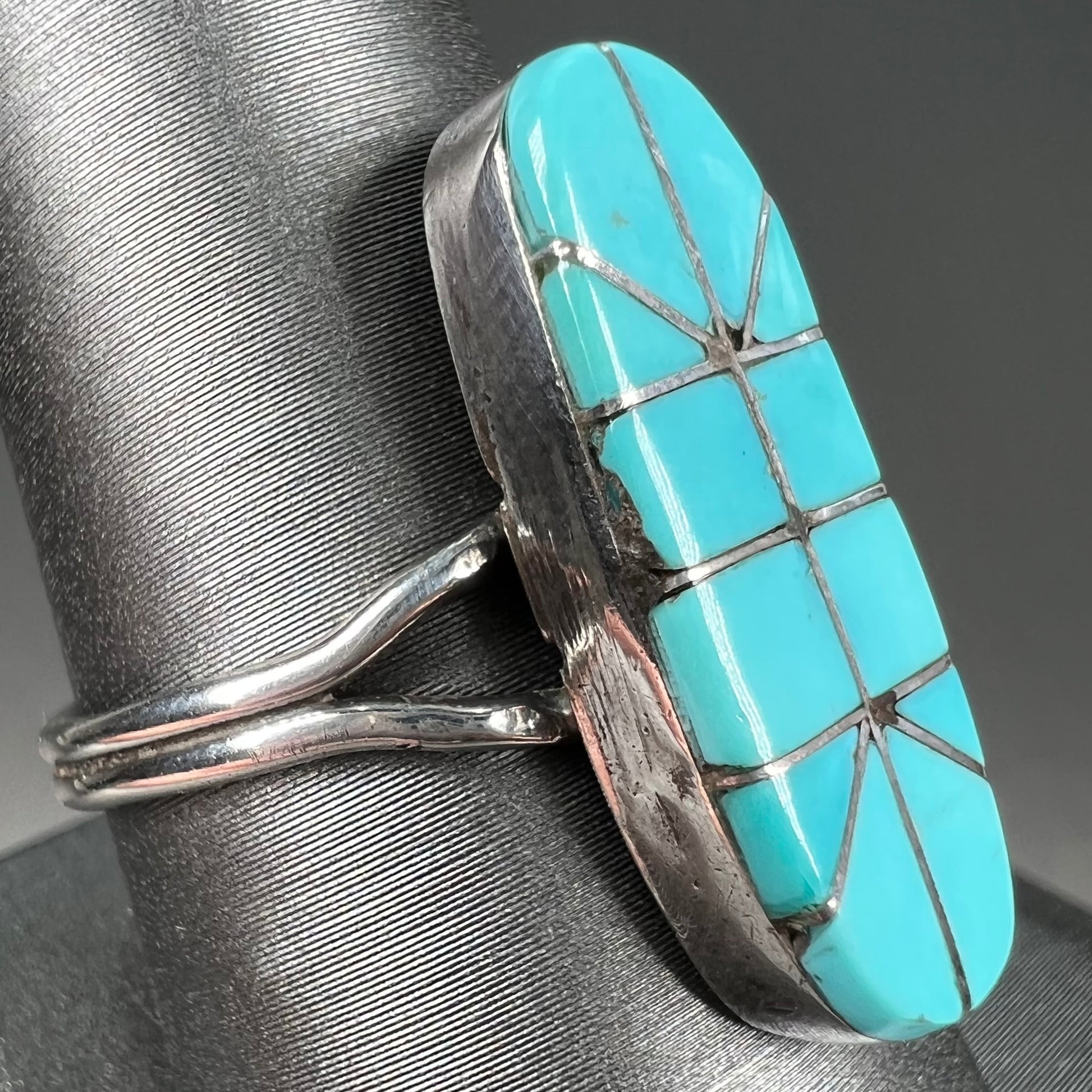 A handmade silver turquoise ring inlaid with six pieces of Sleeping Beauty turquoise.  The back of the ring is signed "FT".