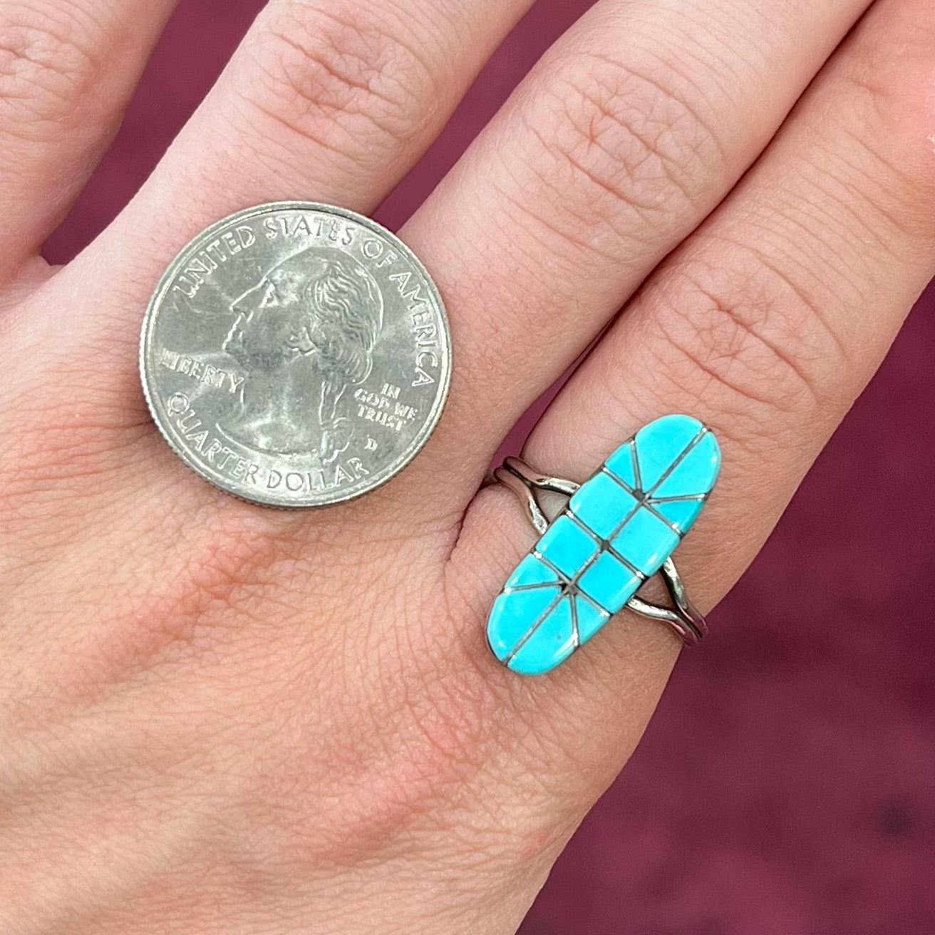 A handmade silver turquoise ring inlaid with six pieces of Sleeping Beauty turquoise.  The back of the ring is signed "FT".